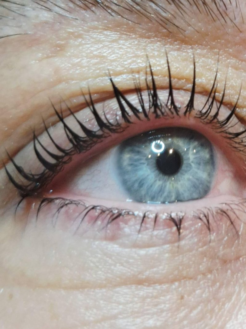 Gekrulde wimpers bij een blauw oog, van dichtbij
