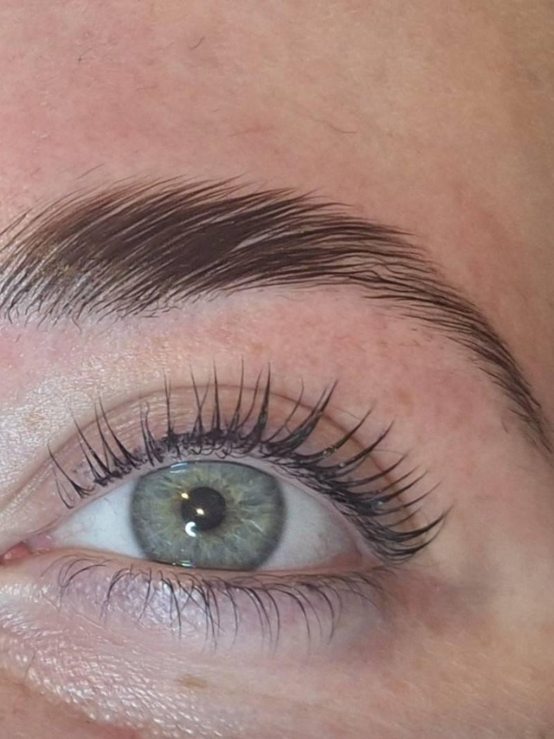Wenkbrauw en wimpers bij een groen oog, van dichtbij